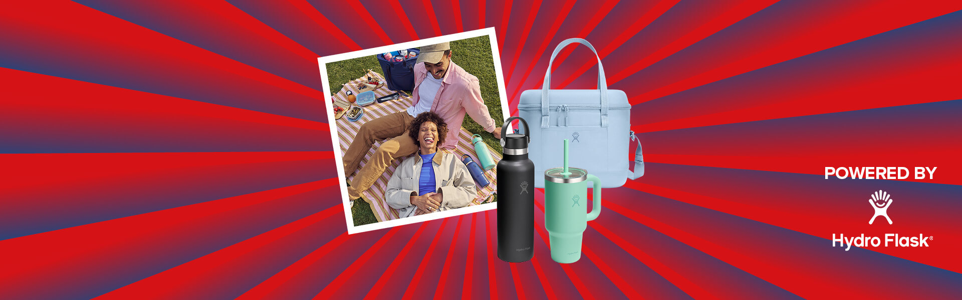 Banner mit rot-blauen Streifen, die sich von der Bildmitte nach außen ziehen. Mitten drin ein Foto, das ein Pärchen beim Picknicken zeigt. Ebenfalls im Banner zu sehen sind Produktbilder (Travel Tumbler, Soft Cooler Tasche, Standard Hydro Flask Flasche), und ein "Powered by" Schriftzug gefolgt von dem Hydro Flask Logo.