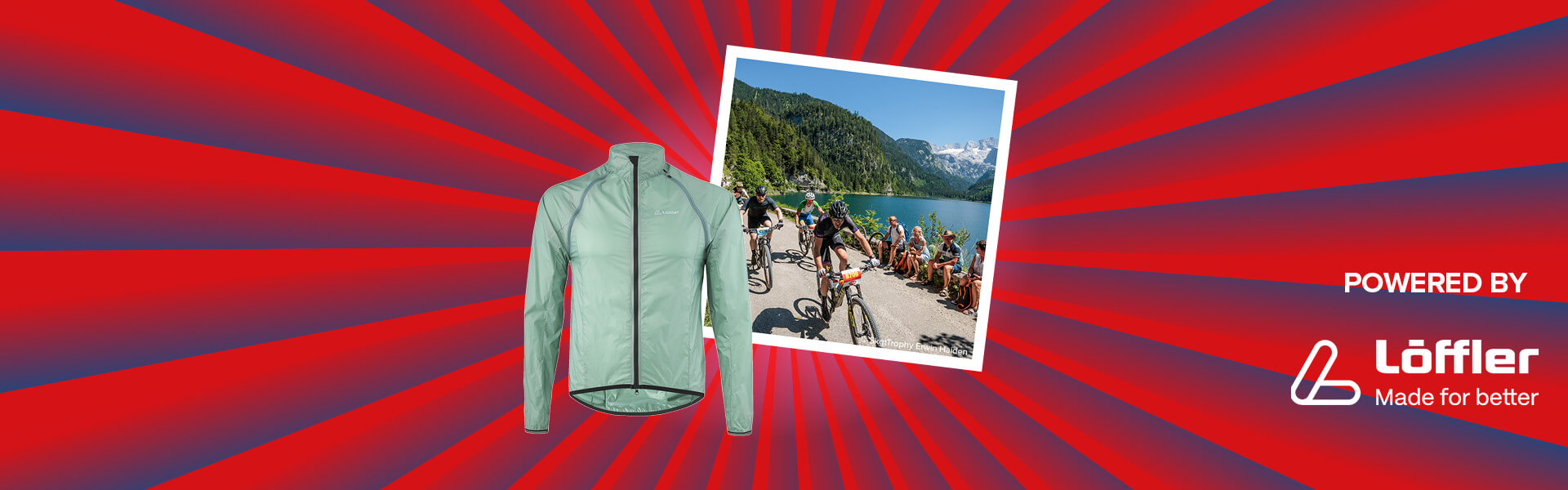 Banner mit rot-blauen Streifen, die sich von der Bildmitte nach außen ziehen. Mitten drin ein Foto, das mehrere Mountainbiker bei der Salzkammergut Trophy zeigt. Ebenfalls im Banner zu sehen sind eine hellgrübe Jacke von Löffler und ein "Powered by" Schriftzug gefolgt von dem Löffler Logo.